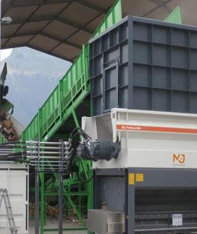 Shredder feeding a green infeed conveyor on site