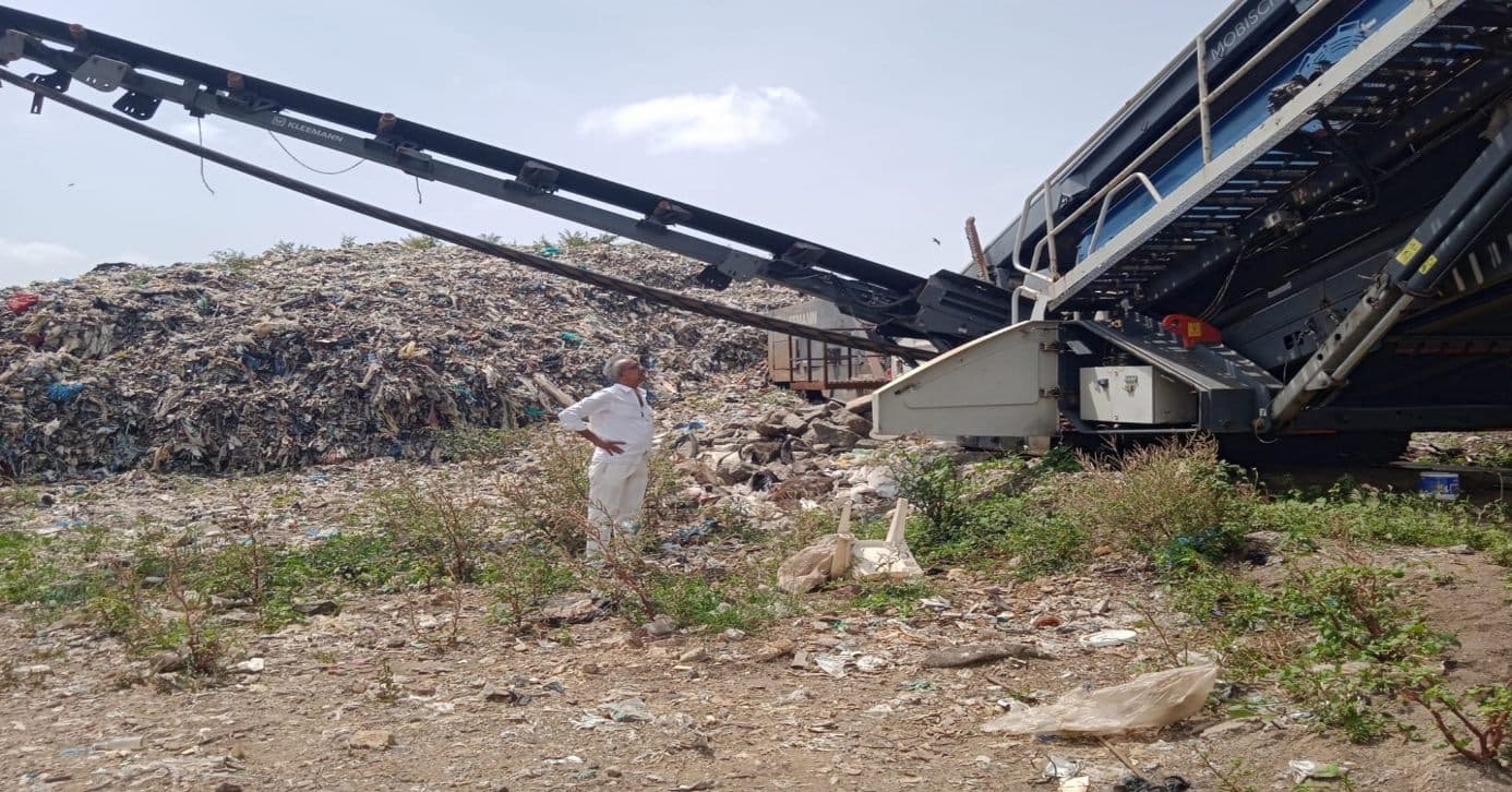 Conveyor system positioned at a landfill ahead of mechanized processing